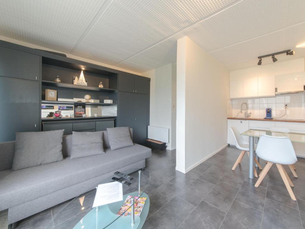 uma sala de estar com um sofá, uma mesa e uma cozinha em Studio Mimosa 007 by Interhome em De Haan