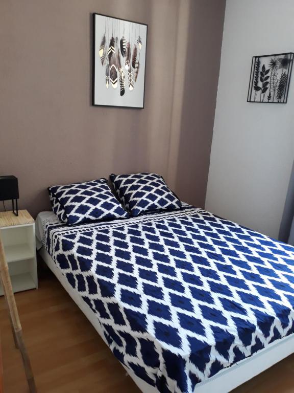 - un lit avec une couette bleue et blanche dans une chambre dans l'établissement 5 minutes des Arènes, parking gratuit, 6 couchages, à Nîmes