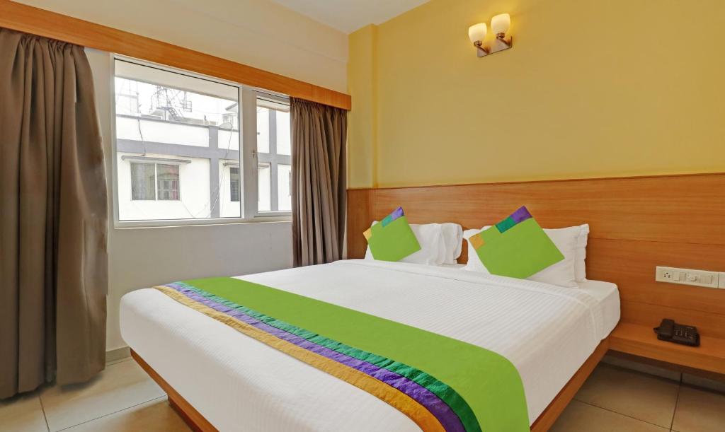 Treebo Trend Fortune Stay في بانغالور: غرفة نوم بسرير كبير مع نافذة