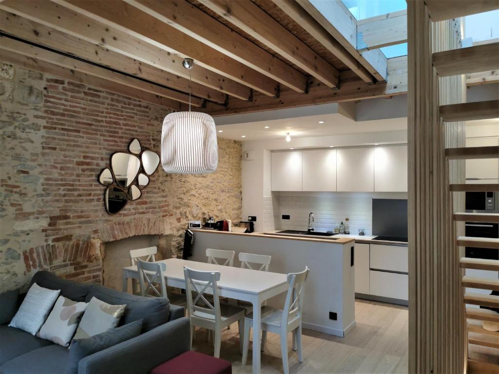 a kitchen and living room with a table and chairs at Ancienne sous-prefecture in Les Sables-dʼOlonne