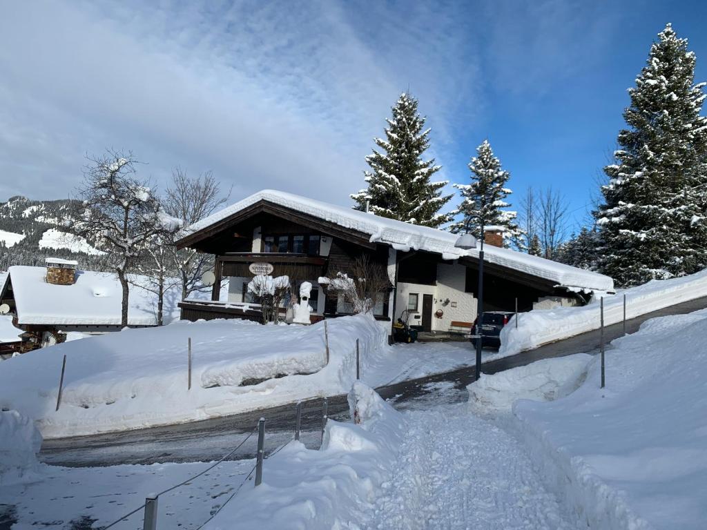 a house covered in snow in front at Landhaus Alpenstern in Riezlern