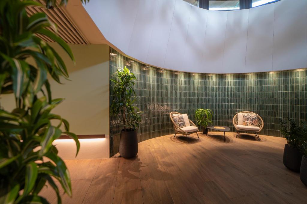 a room with two chairs and potted plants at Savoy Beach Hotel & Thermal Spa in Bibione