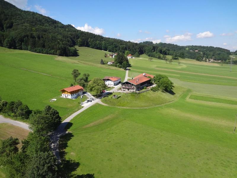 an aerial view of a house in a green field at Ferienwohnung Jagdhäusl in Bernau am Chiemsee