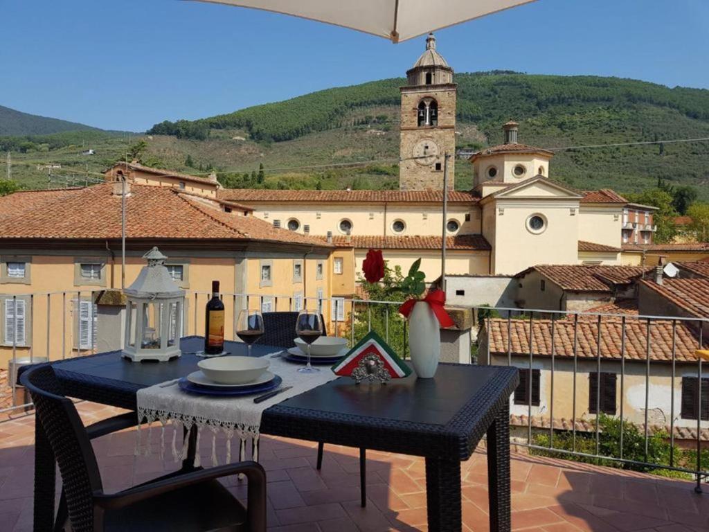 une table et des chaises noires sur un balcon avec un bâtiment dans l'établissement Apartment Appartamento Valle Verde by Interhome, à Buti