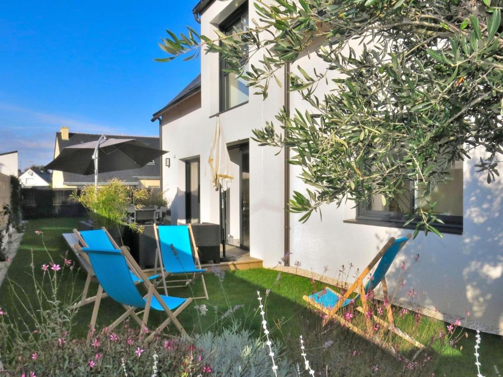 a pair of blue chairs in the yard of a house at Holiday Home Villa LANKA by Interhome in Arzon