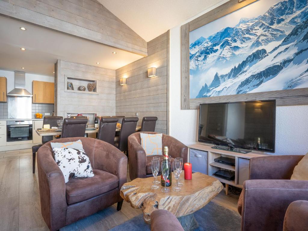 uma sala de estar com uma televisão e uma mesa e cadeiras em Apartment Rond Point des Pistes - Val Claret-17 by Interhome em Tignes