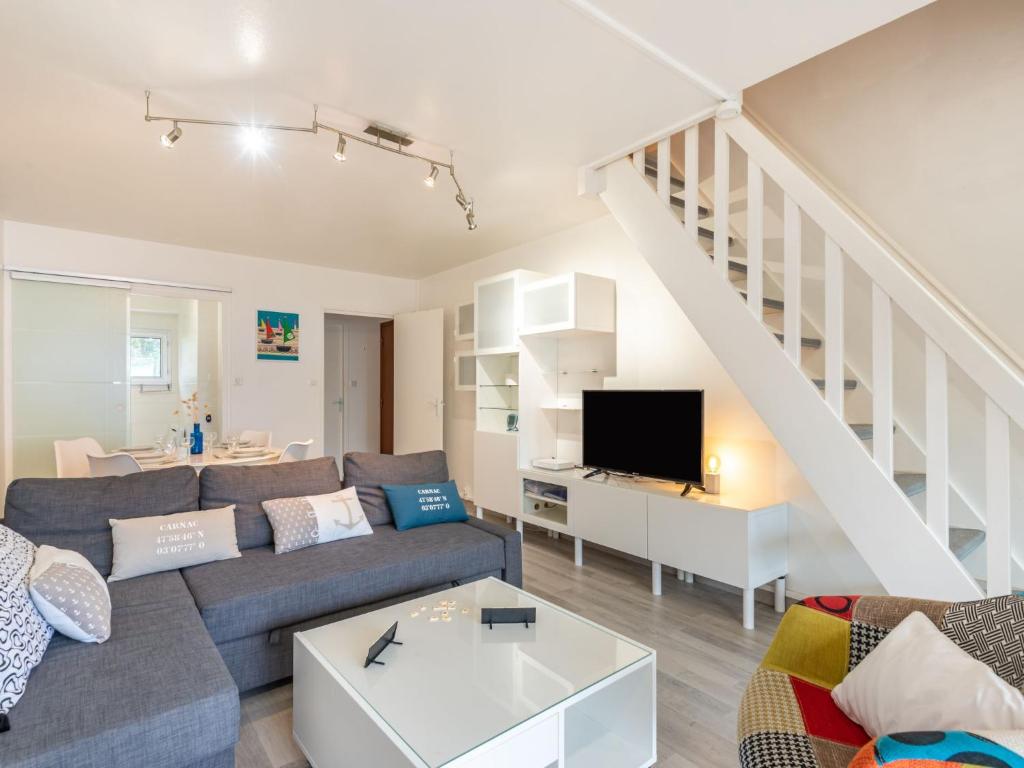 a living room with a couch and a tv at Apartment Ker Eol by Interhome in Carnac
