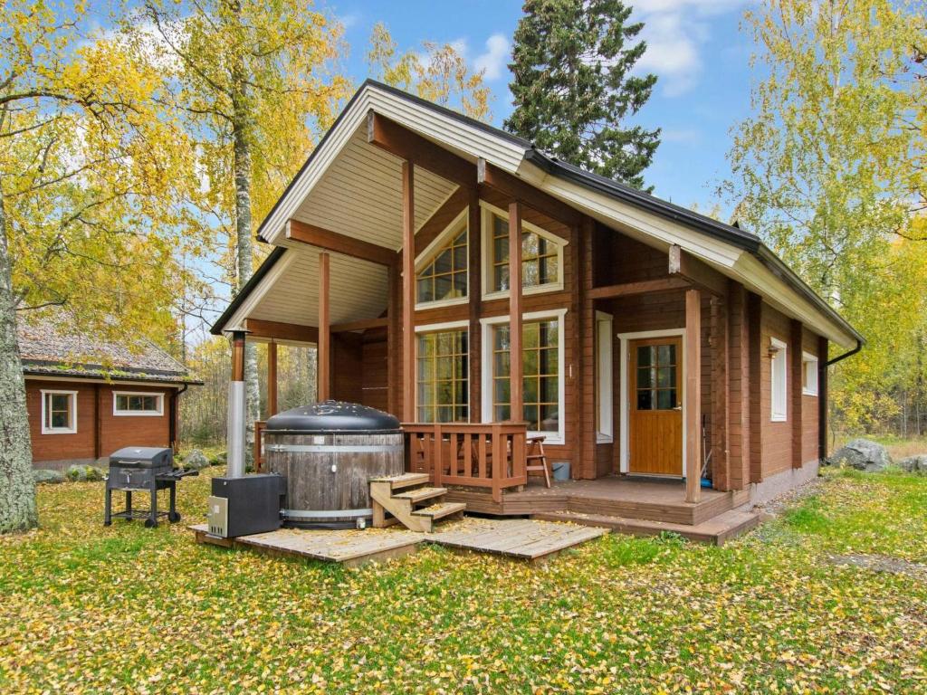 ein winziges Haus mit einem großen Grill und einer Feuerstelle in der Unterkunft Holiday Home Anttoora 4 by Interhome in Pori