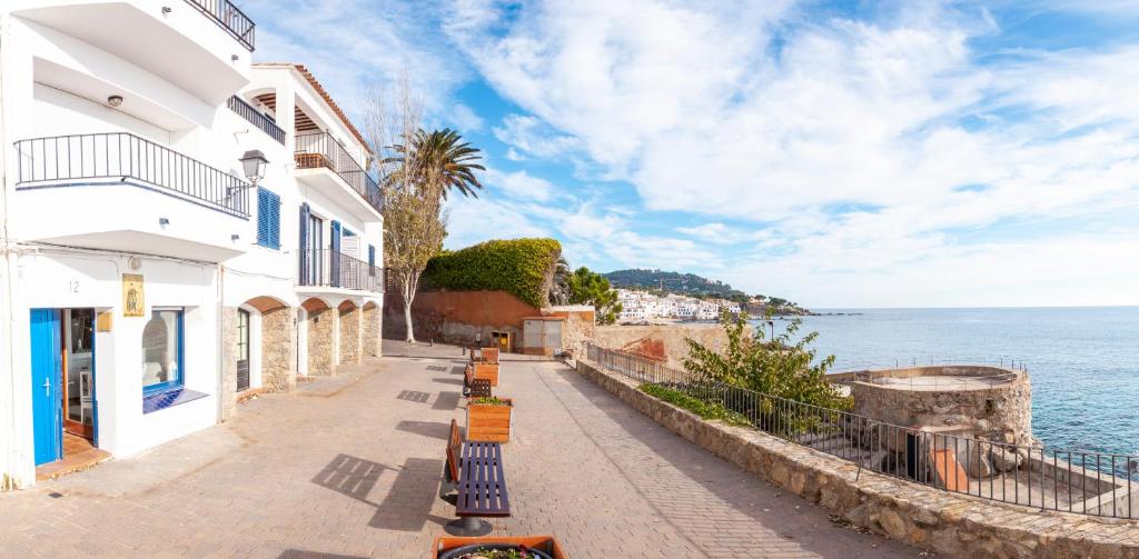 una calle junto al océano con edificios en ELS CANYERS en Calella de Palafrugell