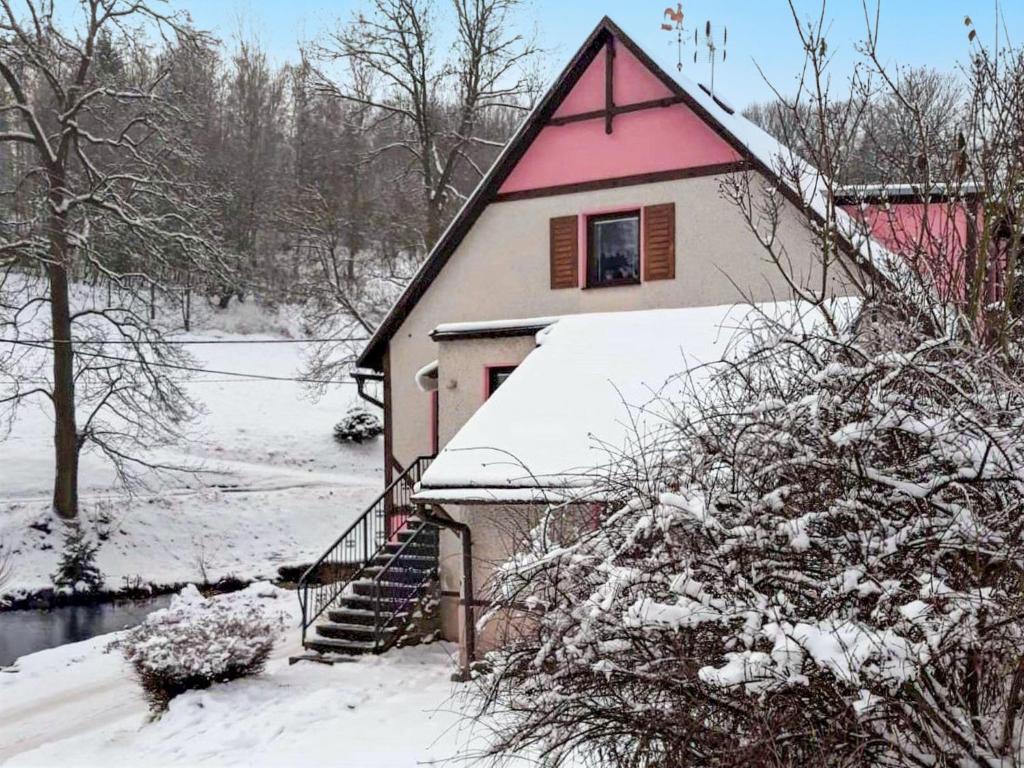 ein Haus mit einem rosa Dach im Schnee in der Unterkunft Holiday Home Chlívce u Hronova-5 by Interhome in Chlívce