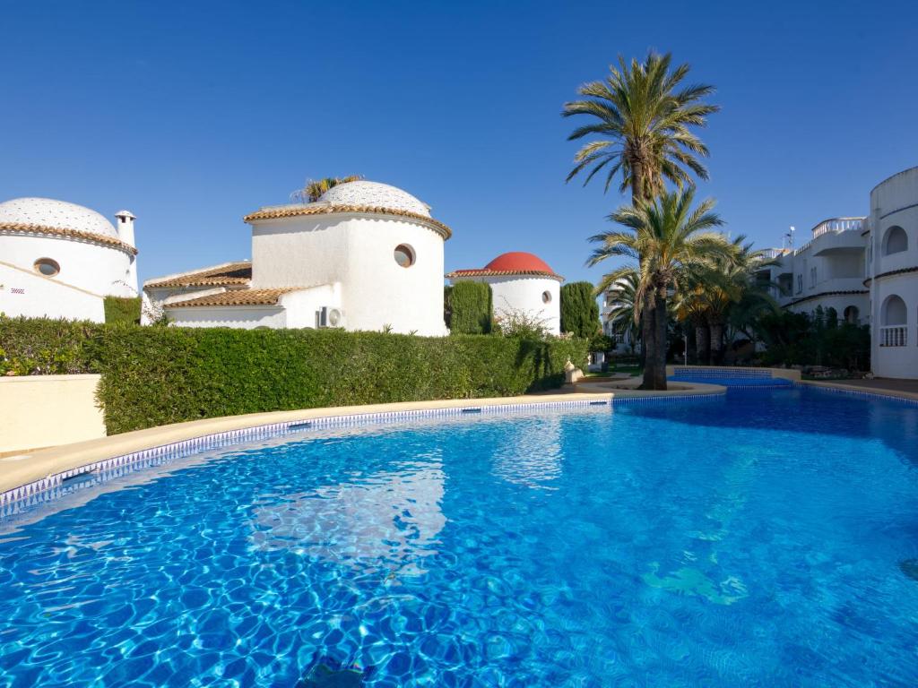 uma piscina em frente a um edifício com palmeiras em Holiday Home La Alhambra by Interhome em Denia