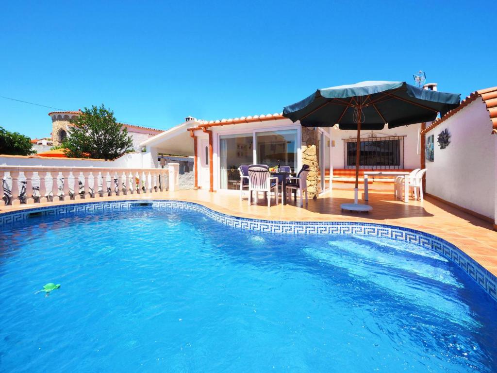 einen Pool mit einem Sonnenschirm und einer Terrasse in der Unterkunft Holiday Home Peni by Interhome in Empuriabrava