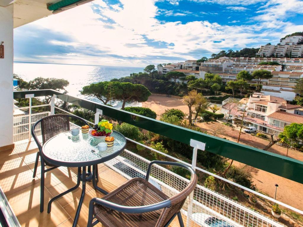 balcón con mesa, sillas y vistas al océano en Apartment Apt Naranja by Interhome, en Tossa de Mar