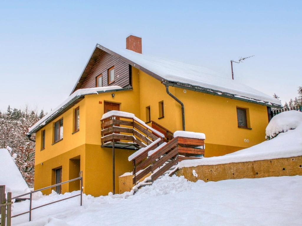 a yellow house with snow on the roof at Holiday Home Dolníky u Trutnova by Interhome in Oblanov