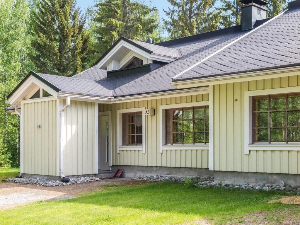 a house with yellow siding and a gray roof at Holiday Home Tintintaival 2 a 8 by Interhome in Tahkovuori