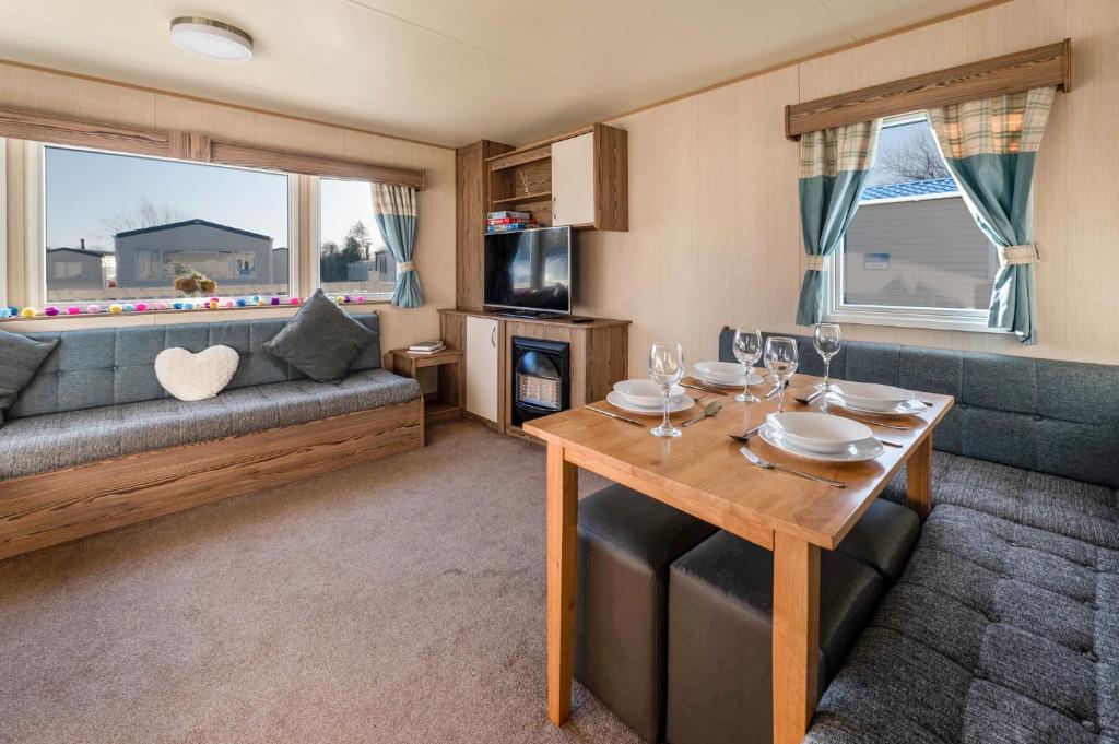 Lakeside, Thorpe Park Cleethorpes Static Caravan في كْليثوربس: غرفة معيشة مع طاولة وأريكة