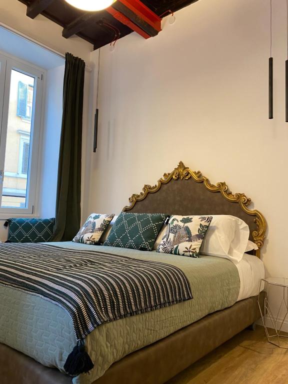 a bedroom with a bed with a large headboard at Casa Leoncino B&B in Rome