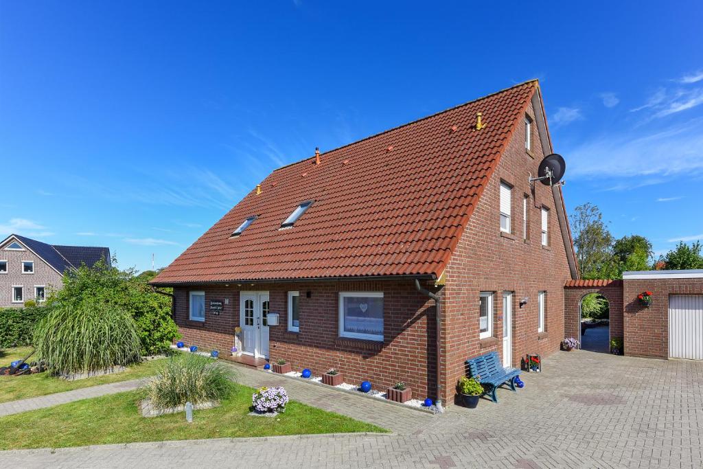 ein Backsteinhaus mit rotem Dach in der Unterkunft Ferienwohnung Trautes Heim in Bensersiel