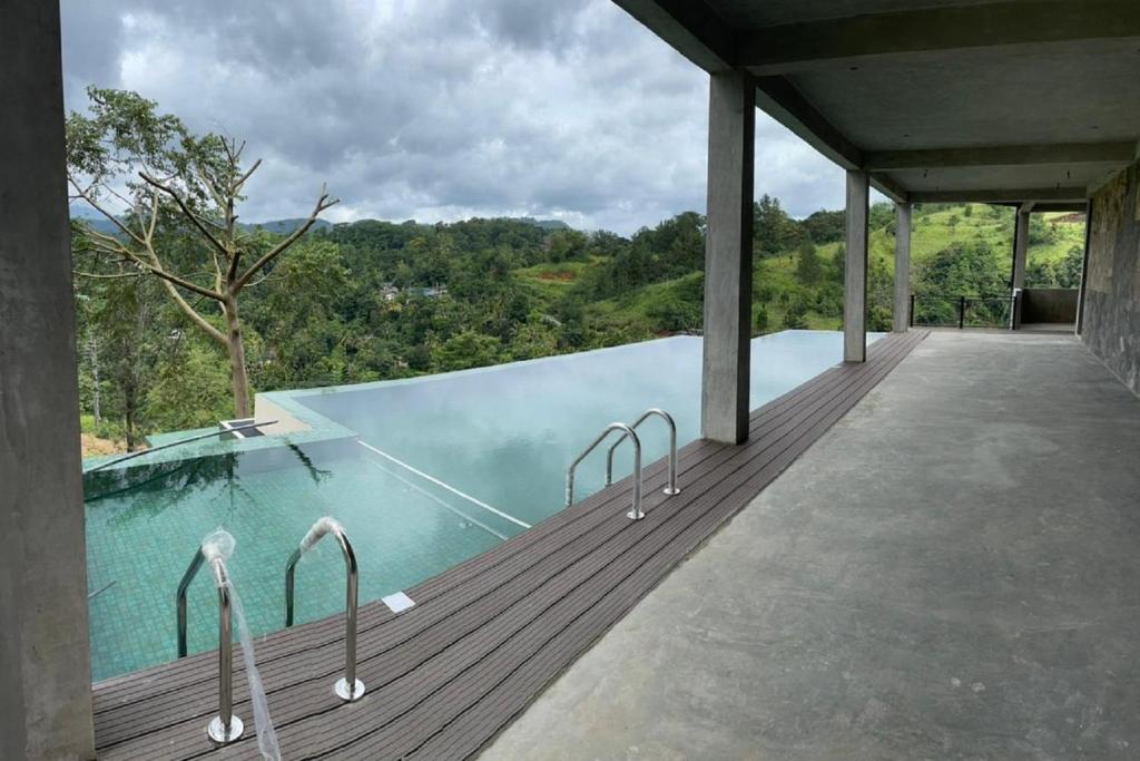 una piscina en una terraza de madera con vistas en Riverbank Resort Gampola en Gampola