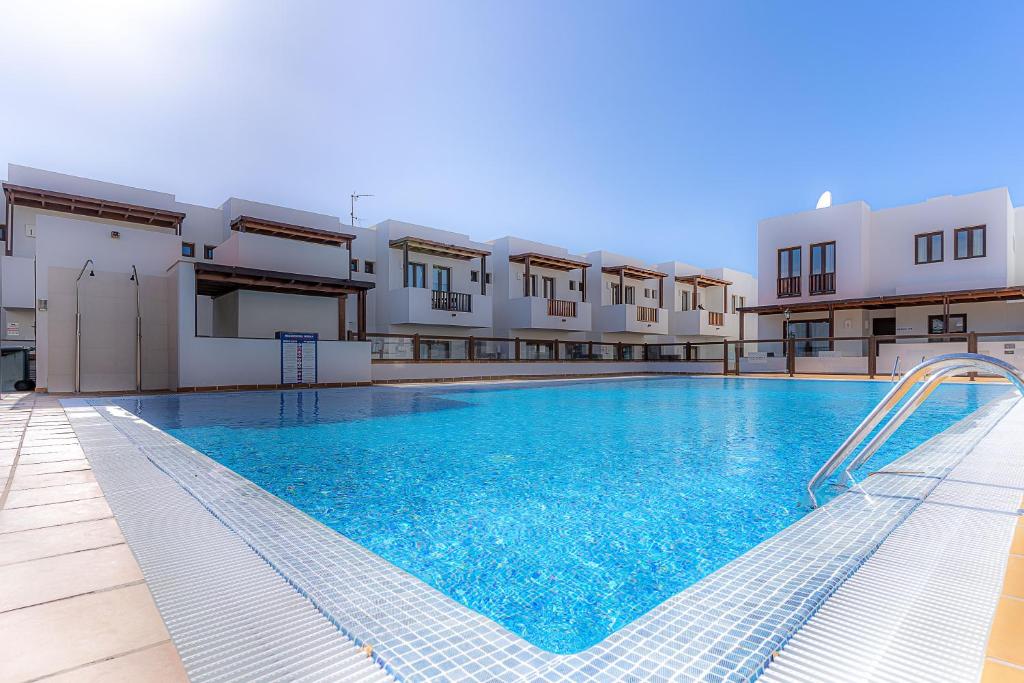 ein großer Pool vor einigen Gebäuden in der Unterkunft Casa Kaliste in Puerto Calero