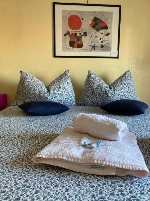 ein Bett mit blauen Kissen und einem Handtuch darauf in der Unterkunft JFK b & b in Ciampino