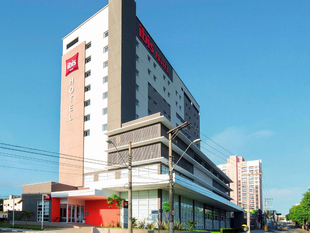 un edificio alto con un cartel en el costado en ibis Mogi das Cruzes Shopping, en Mogi das Cruzes