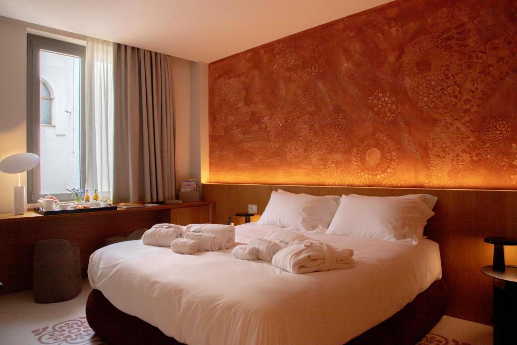 A bed or beds in a room at Ognissanti Restaurant Spa Hotel Rooftop