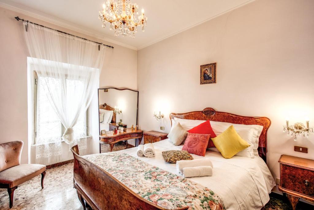 una camera da letto con un letto grande con cuscini colorati di Warm apt in ancient building in Vatican-P S Pietro a Roma