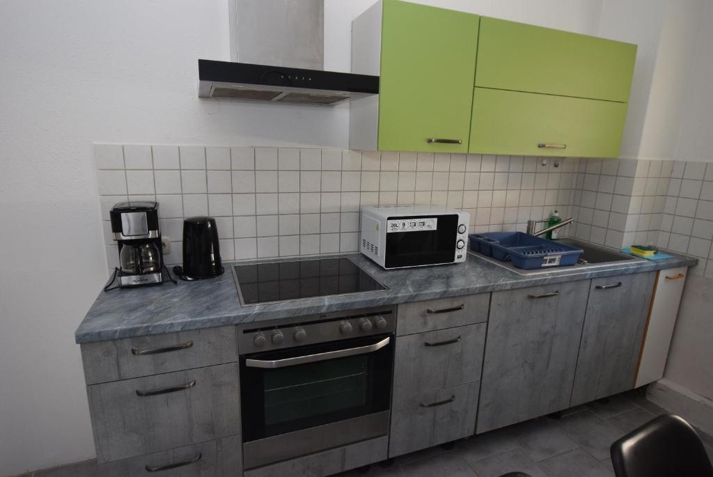 a kitchen with green cabinets and a counter top at Apartment Stuttgart-Rot in Stuttgart
