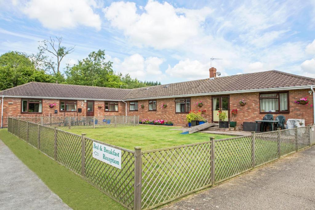 a house with a fence in front of it at Little Bullocks Farm in Takeley