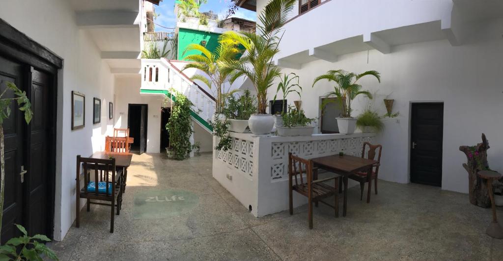una stanza con tavolo, sedie e piante in vaso di zLife Stone Town a Zanzibar City