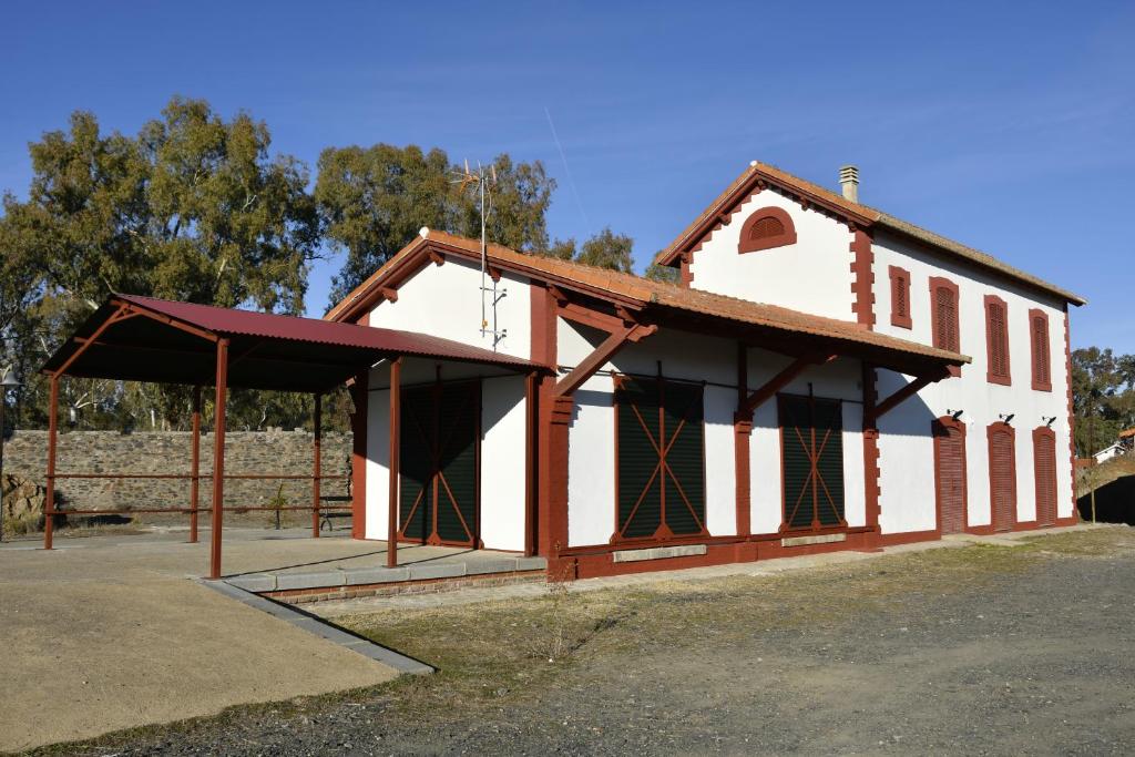 biało-brązowy budynek z czerwonym dachem w obiekcie Casa Rural ESTACIÓN DEL SOLDADO w mieście Estación del Soldado