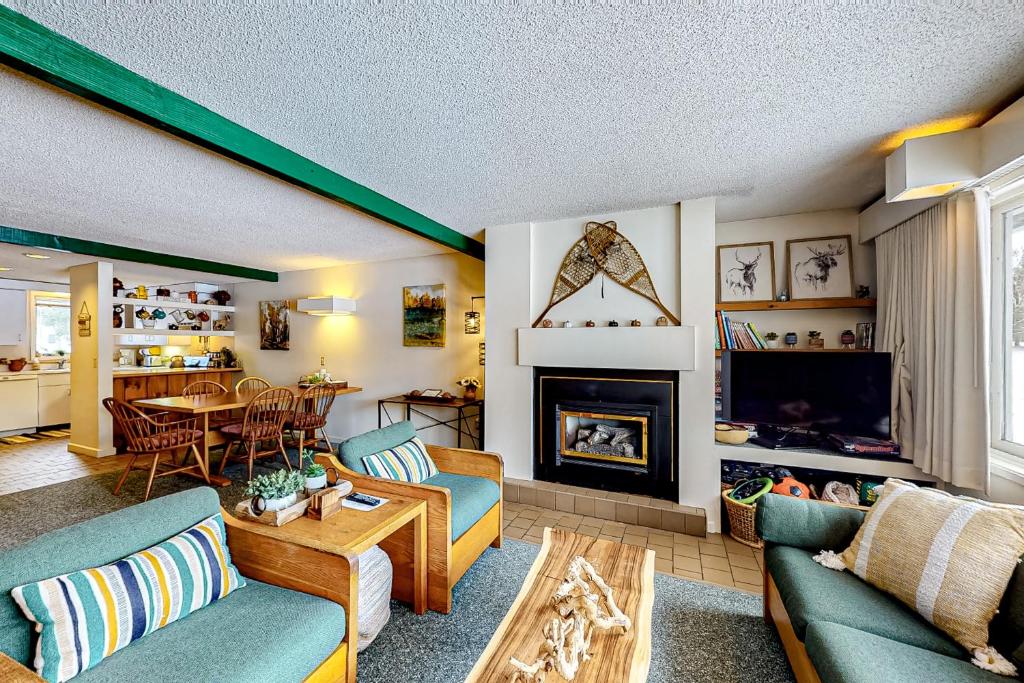 a living room with blue couches and a fireplace at Village Green II in Stowe