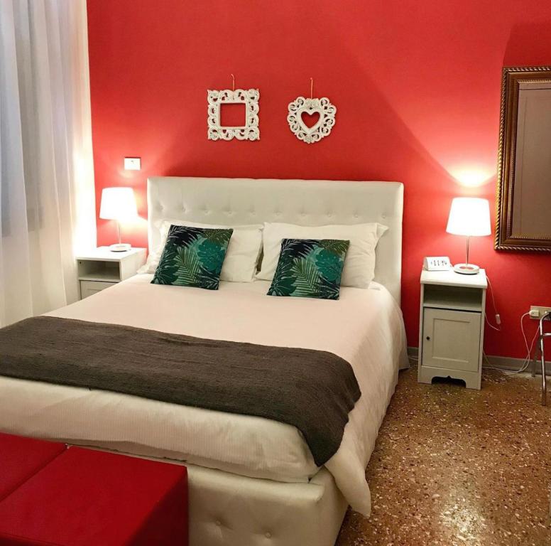 a bedroom with a red wall with a large bed at Residenza Quaggio Ca' Grimani in Venice