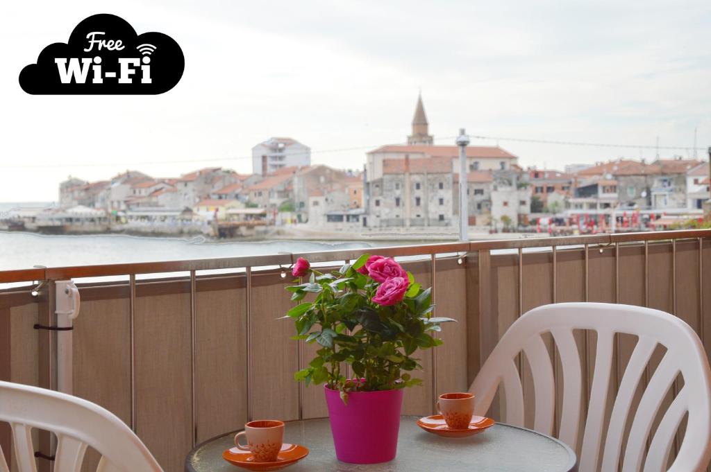 a table with a vase with a flower on a balcony at Apartment Riva sea view in Umag