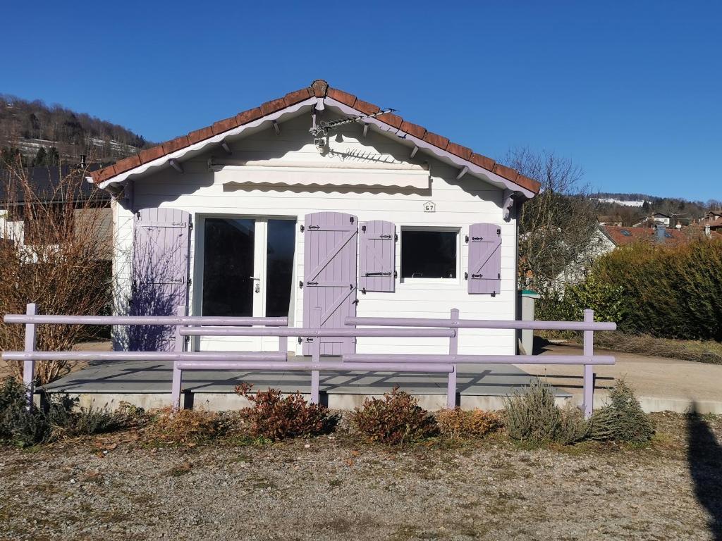une petite maison avec des portes violettes et une clôture dans l'établissement Chalet entre lacs et montagnes, à Saulxures-sur-Moselotte