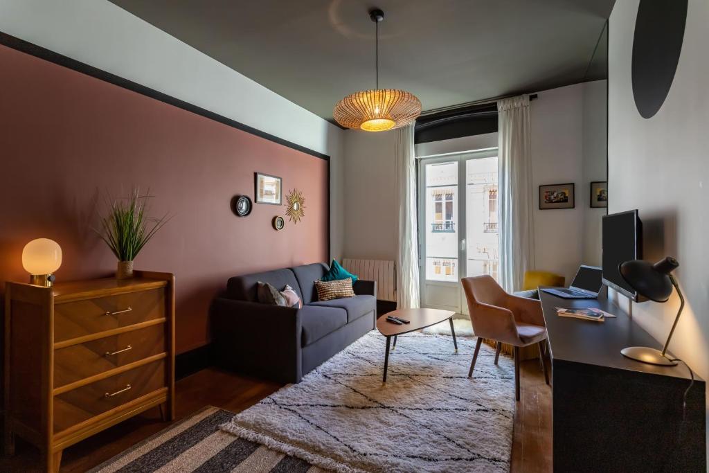 een woonkamer met een bank en een tafel bij LE COURSIVE - Charmant T2 à Villeurbanne in Villeurbanne