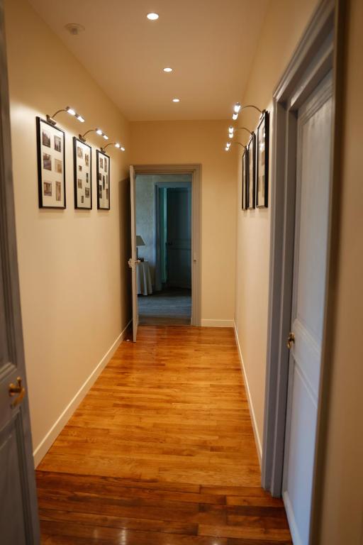a hallway with wood floors and pictures on the walls at Maison de vacances _ Le Bas Manoir in Bretteville-sur-Odon