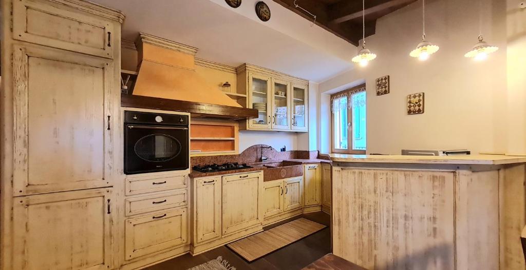 a kitchen with wooden cabinets and a black microwave at Appartamento LO SCOIATTOLO in Andalo