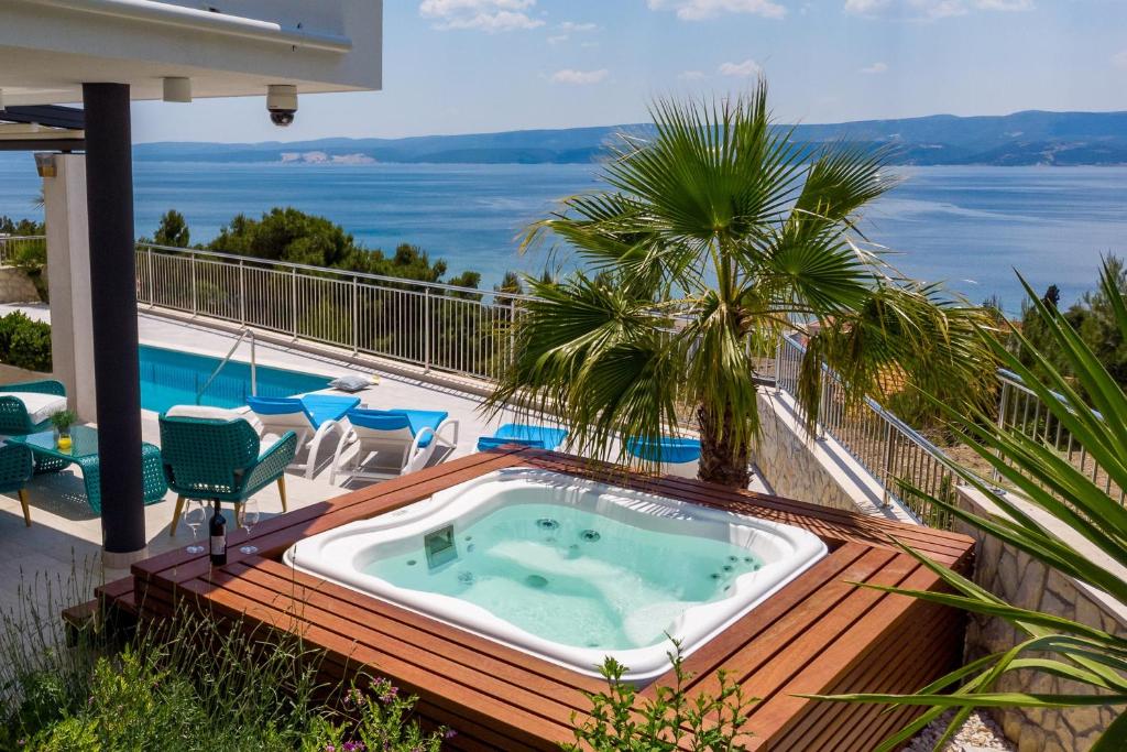 uma banheira de hidromassagem num deque com vista para o oceano em Seaview Villa Marija with Pool, Jacuzzi, Sauna em Duće