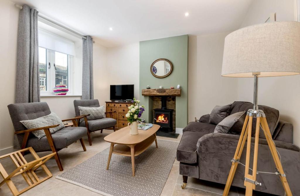 a living room with a couch and a fireplace at Wall Cottage in Burford