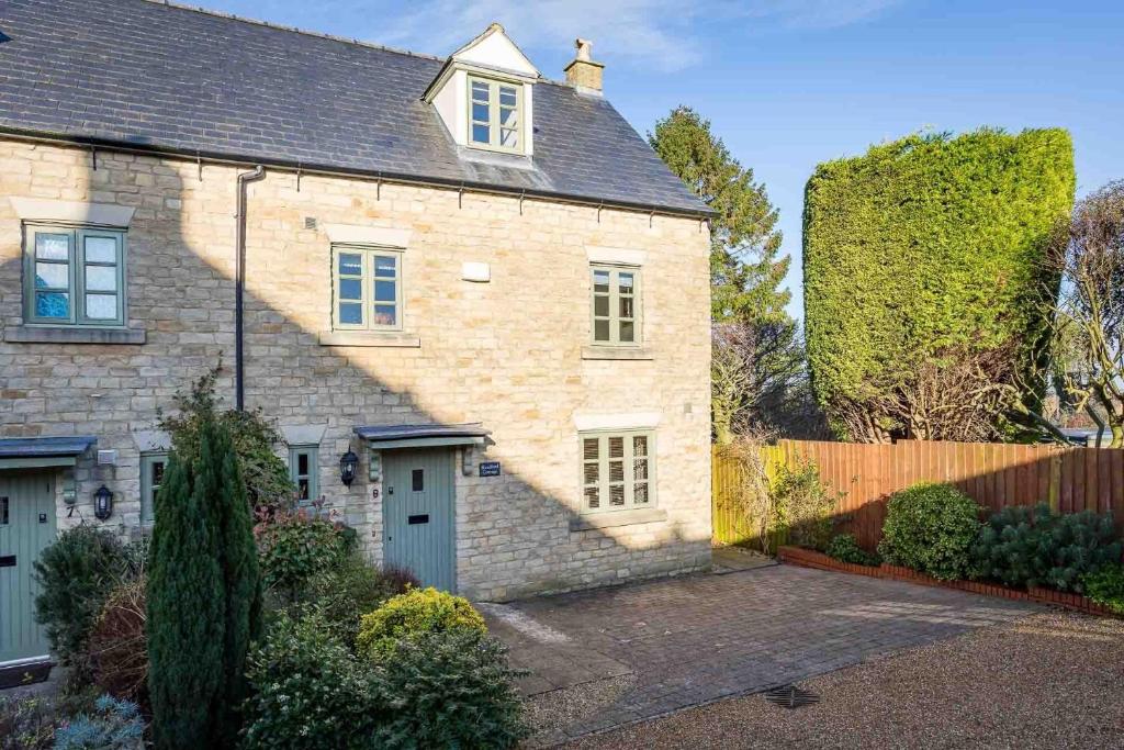 una casa de ladrillo con una entrada delante de ella en Headford Cottage, en Stow on the Wold