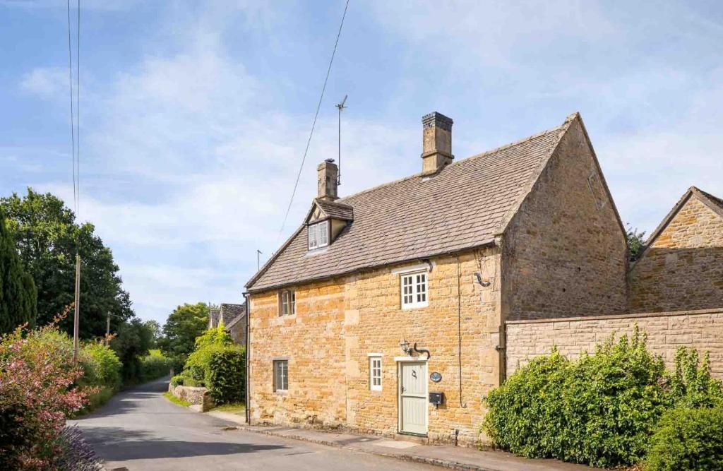 an old brick cottage with a driveway at Court Hayes in Cheltenham