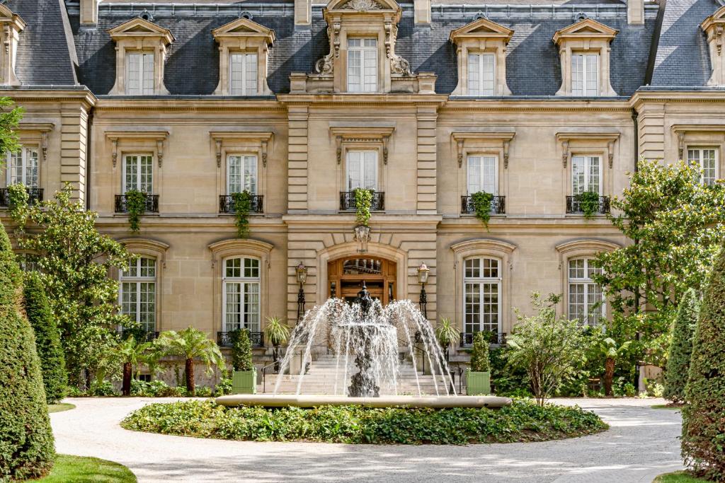 une fontaine devant un bâtiment dans l'établissement Saint James Paris, à Paris