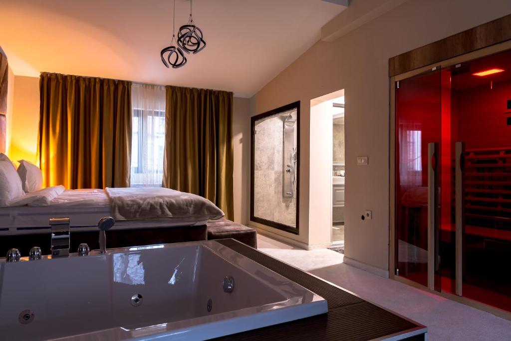 Cappo suites في فيليكو ترنوفو: حمام كبير مع حوض استحمام وسرير
