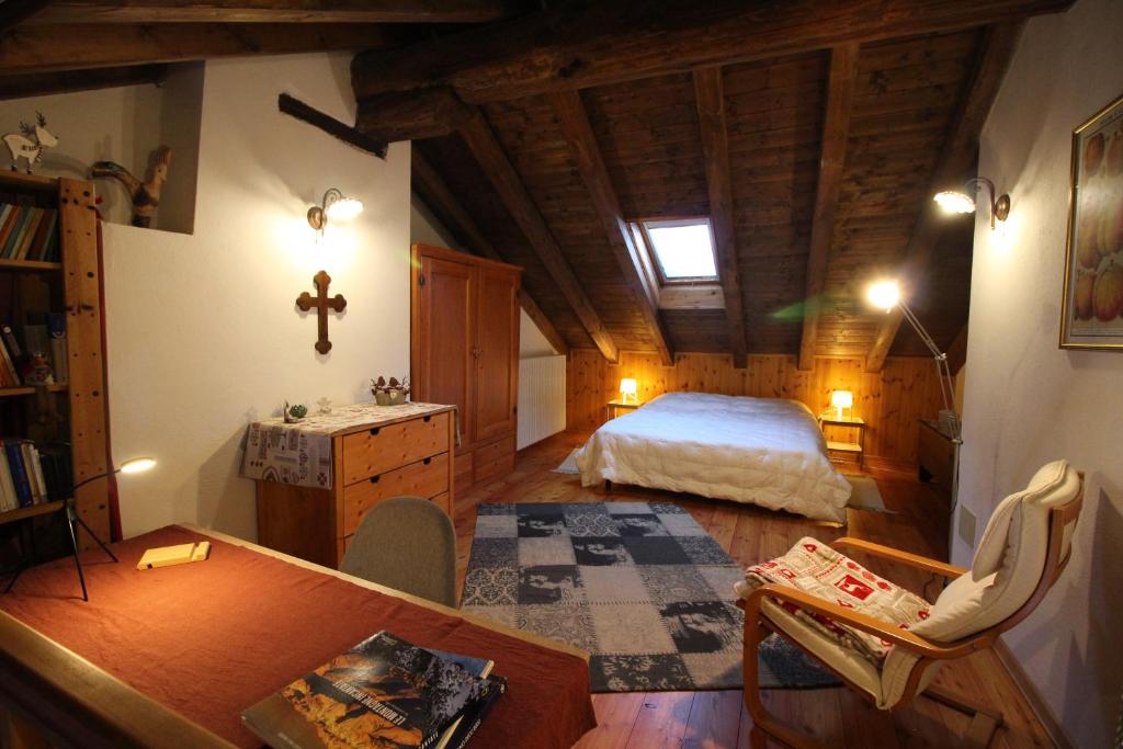 1 dormitorio con 1 cama y 1 cruz en la pared en La Casetta in Montagna Roisod - Affitti Brevi Italia, en Gignod