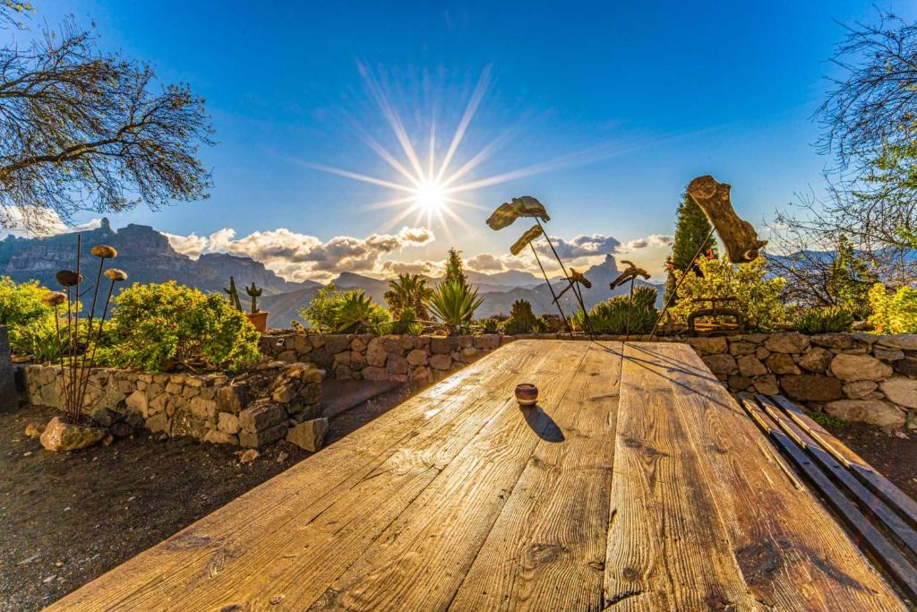 a wooden table with the sun in the background at Finca La Isa in Tejeda