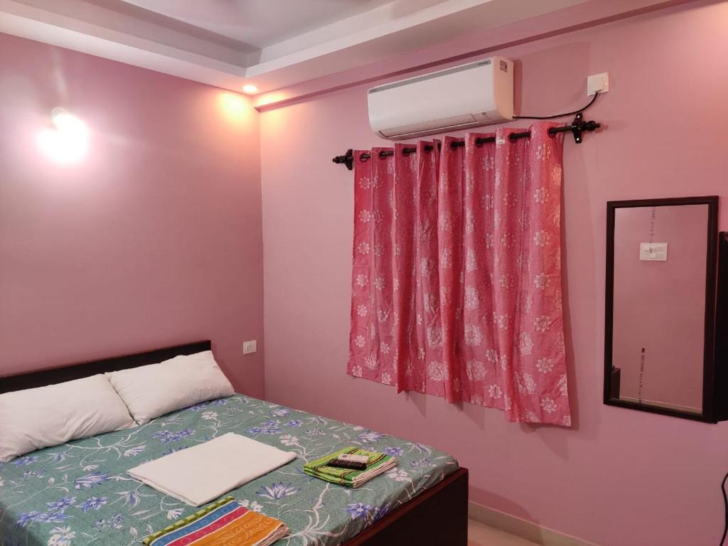 1 dormitorio con 1 cama y ventana con aire acondicionado en INDRAYANI GUEST HOUSE, en Calangute