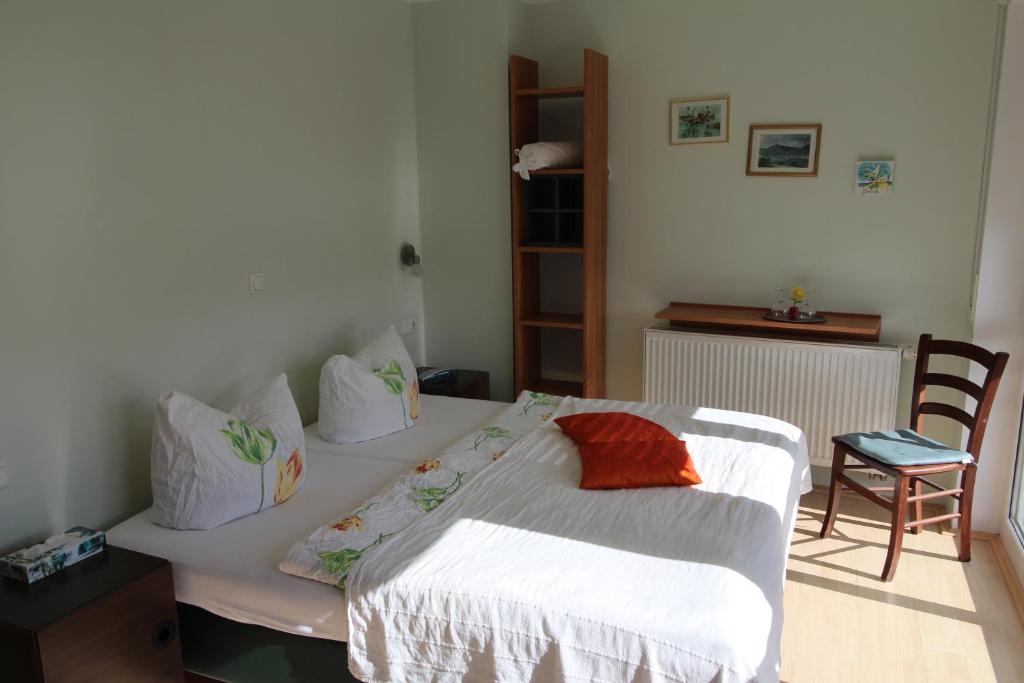 a bedroom with a bed and a table and a chair at Gastehaus Weingut Rossler in Lorch am Rhein