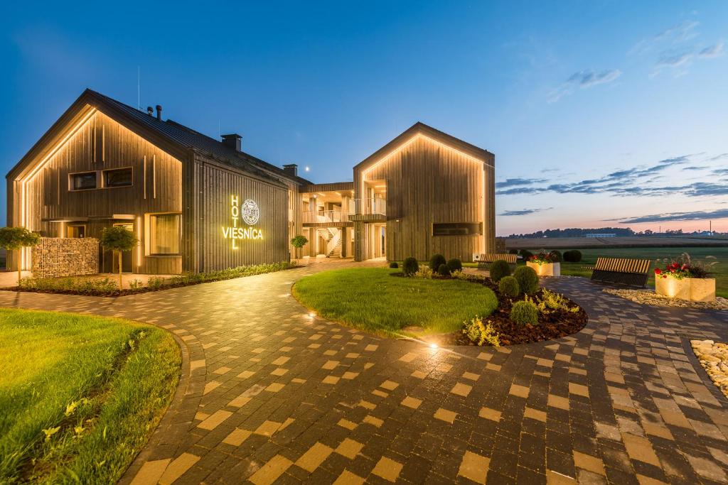 a large house with a courtyard in front of it at Hotel Miķelis in Uzvara